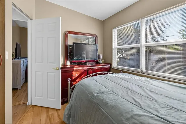 a bedroom with a bed and large windows