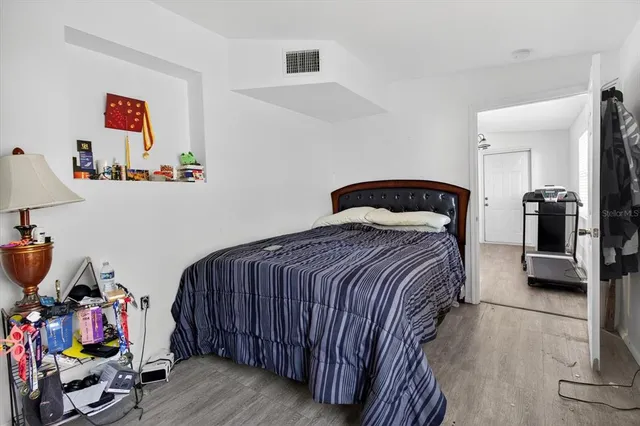 a bedroom with a bed and wooden floor
