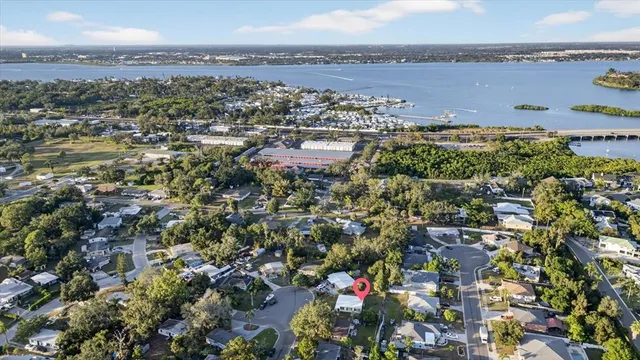 an aerial view of a city with lots of residential buildings ocean and mountain view in back