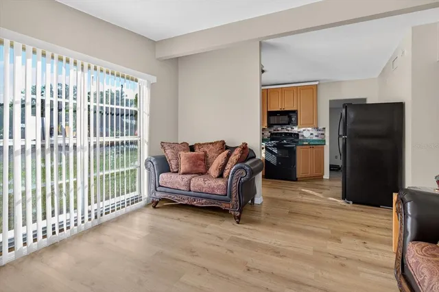 a living room with furniture a refrigerator and a flat screen tv