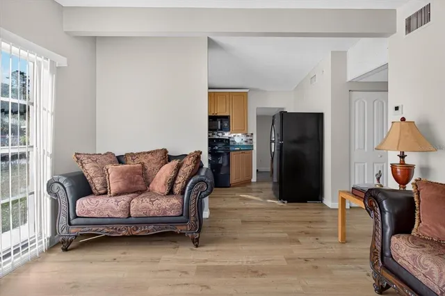 a living room with furniture a refrigerator and a fireplace