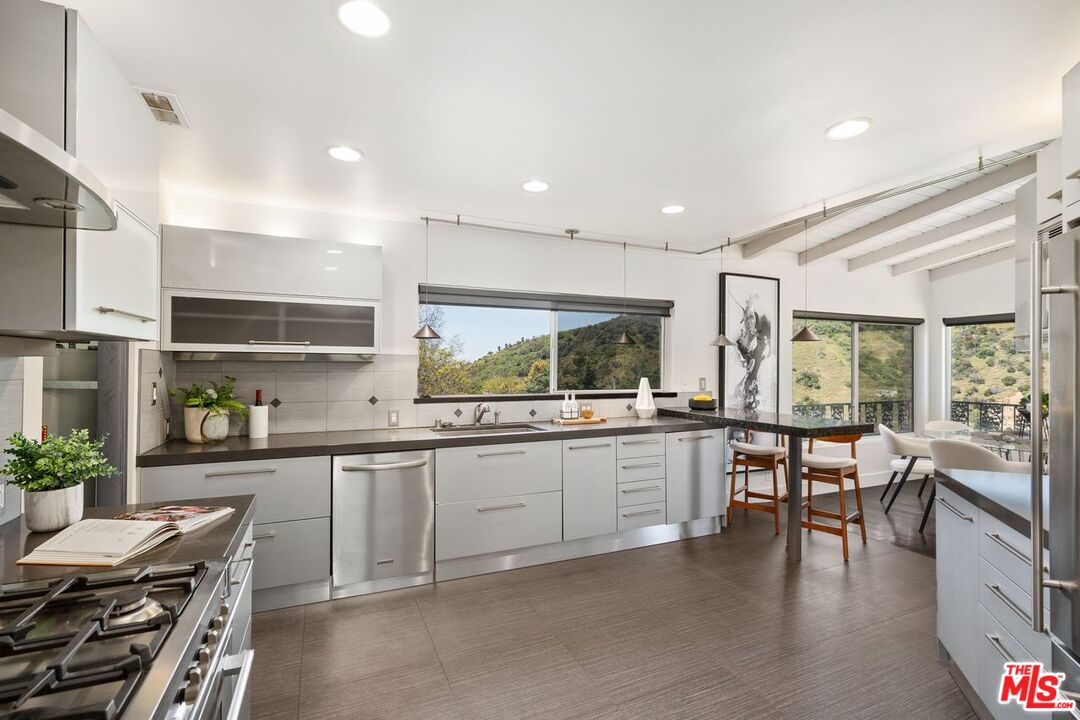 2221 Castilian Drive Los Angeles, CA 90068 - Photo 5 of 15 a kitchen with lots of counter top space and dining table