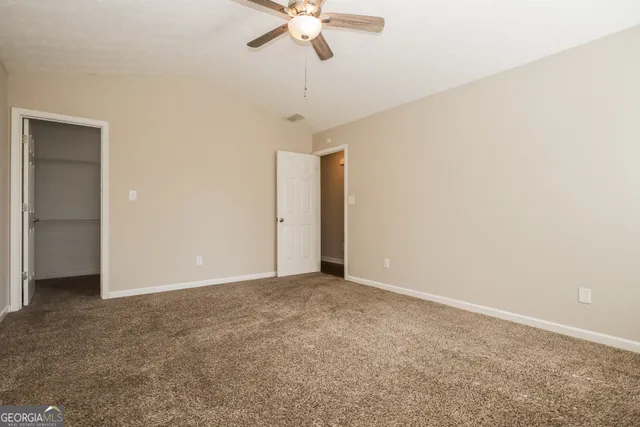 a view of an empty room with a ceiling fan