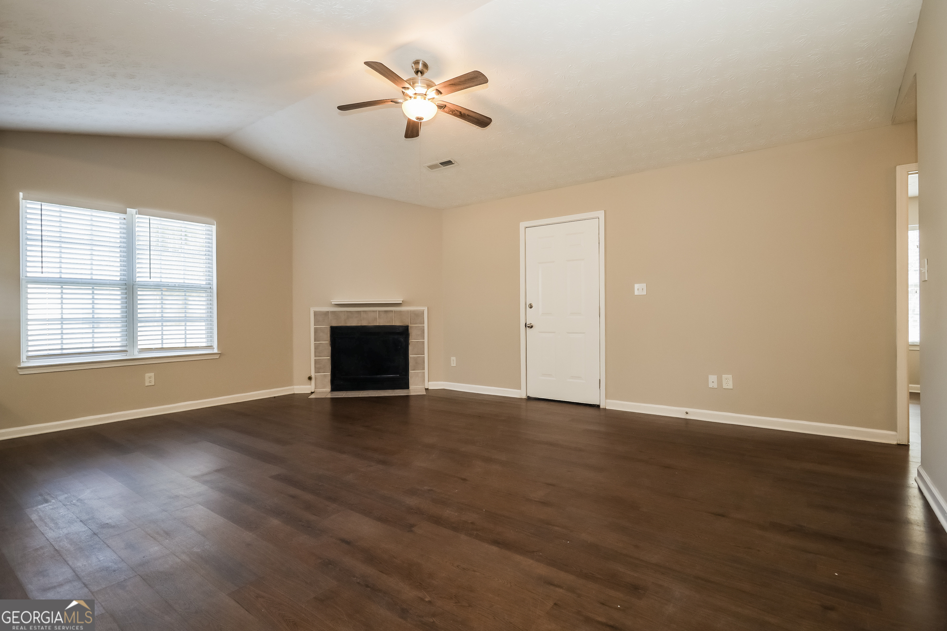 3006 Ryan Road Locust Grove, GA 30248 - Photo 3 of 21 an empty room with wooden floor and chandelier fan