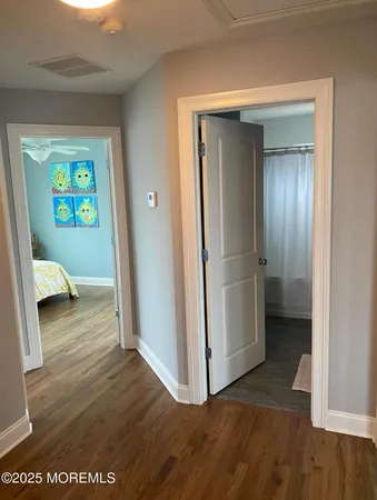 a view of a hallway with wooden floor and closet