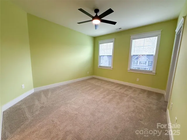 a view of a swimming pool and lounge chairs in back yard of the house