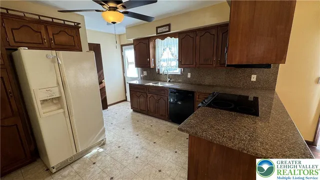 a kitchen with stainless steel appliances granite countertop a refrigerator a sink a stove and island