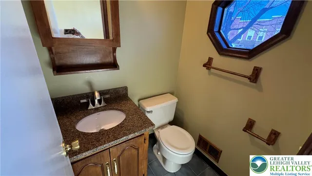 a bathroom with a granite countertop toilet sink and mirror