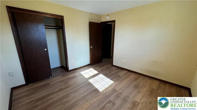 an empty room with wooden floor and closet