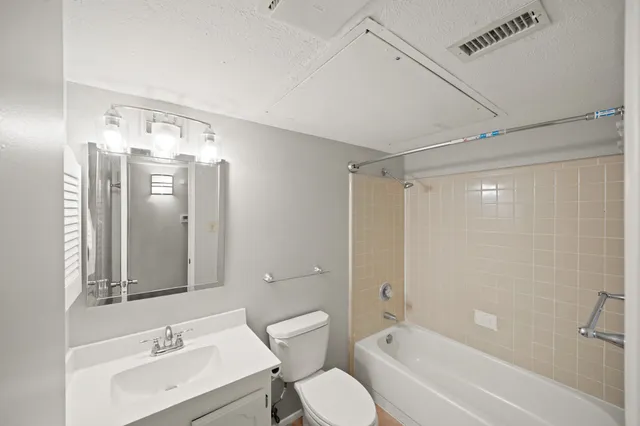 a bathroom with a bathtub shower sink mirror and toilet