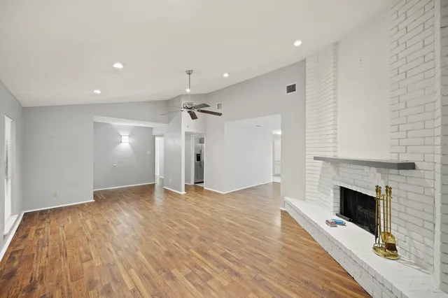 an empty room with wooden floor and fireplace