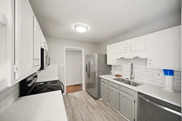 a kitchen with stainless steel appliances a sink a stove and a refrigerator