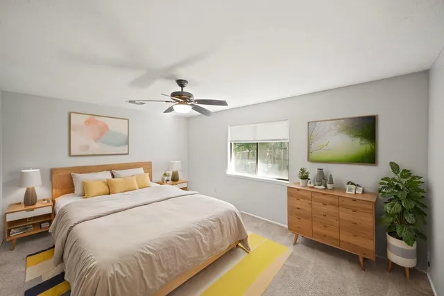 a bedroom with a bed and a flat tv screen on dresser