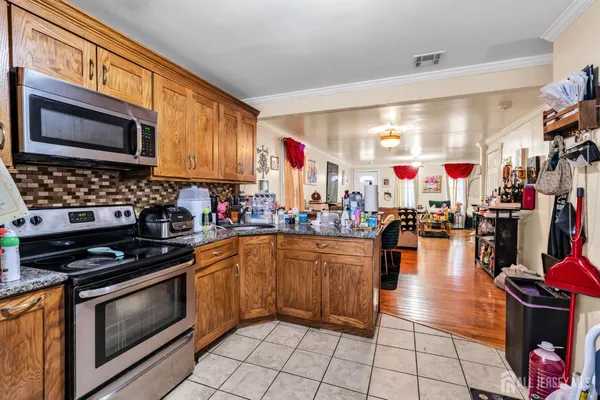a kitchen with stainless steel appliances granite countertop a stove a sink and a microwave