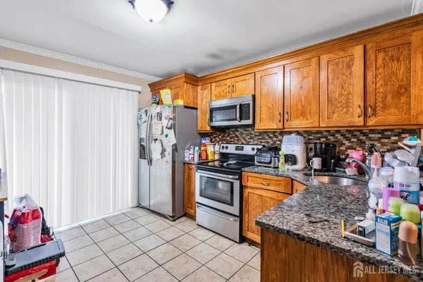 a kitchen with stainless steel appliances granite countertop a refrigerator and a stove top oven
