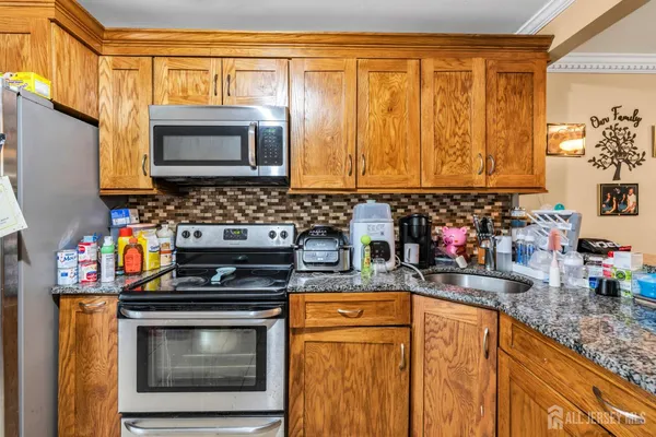 a kitchen with stainless steel appliances granite countertop a stove a sink and a microwave