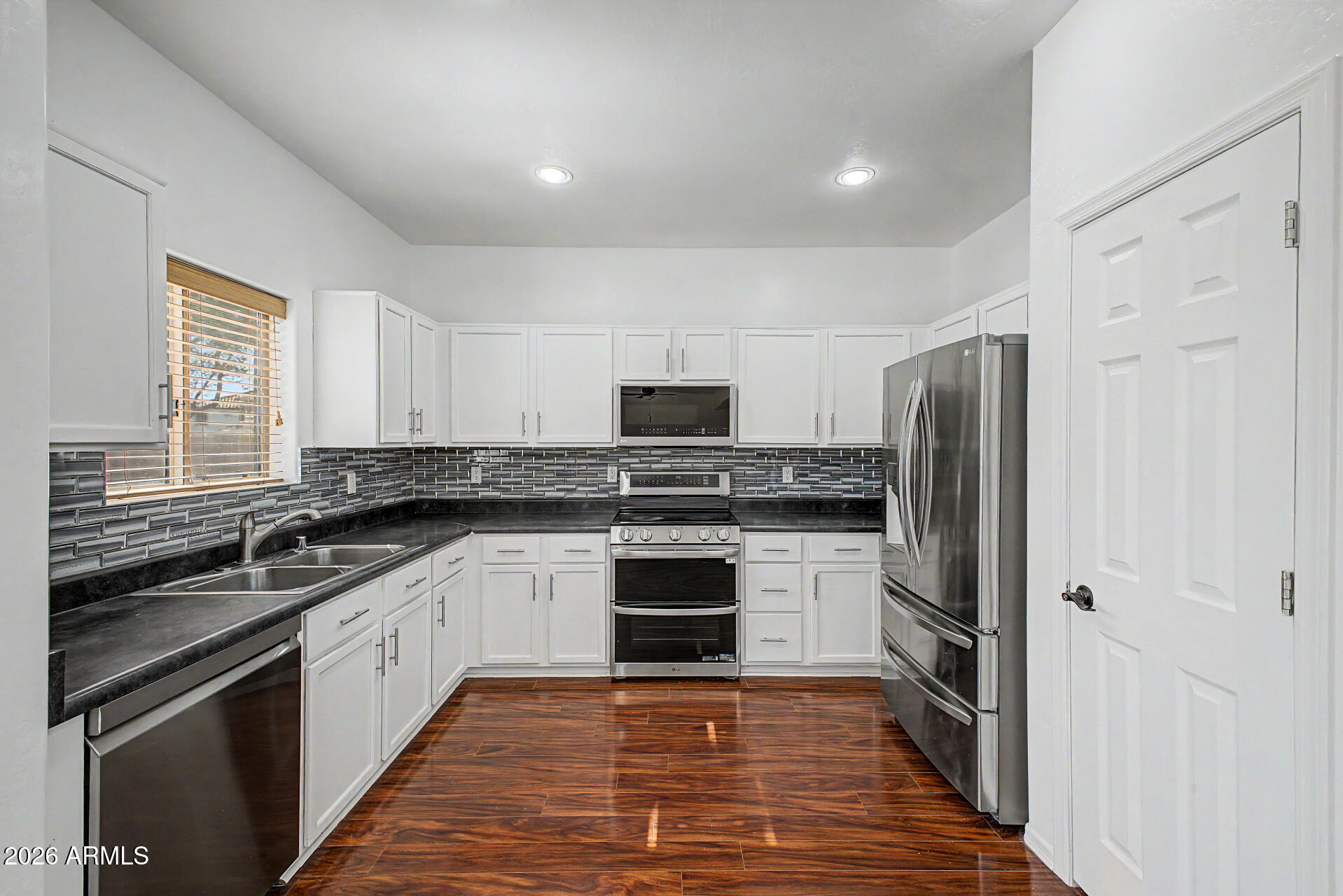 7206 South 12th Way Phoenix, AZ 85042 - Photo 10 of 34 a kitchen with stainless steel appliances granite countertop a stove top oven a sink and a refrigerator