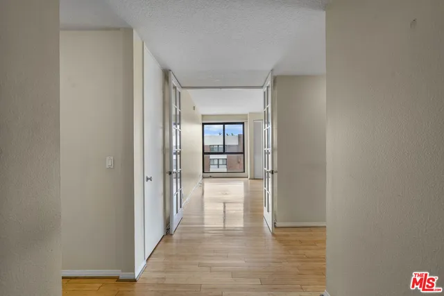 a view of a hallway with wooden floor and closet