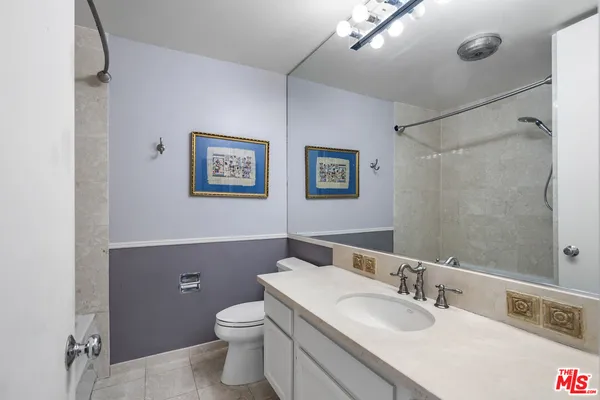 a bathroom with a granite countertop sink mirror vanity and toilet