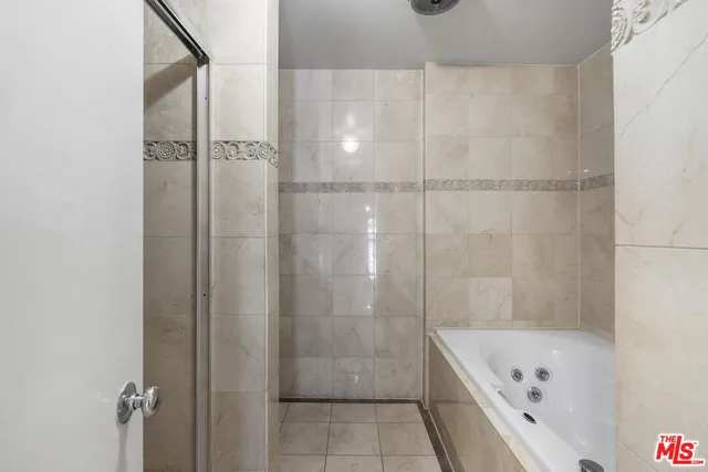 a bathroom with a tub a shower and vanity