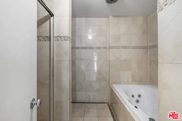 a bathroom with a tub a shower and vanity