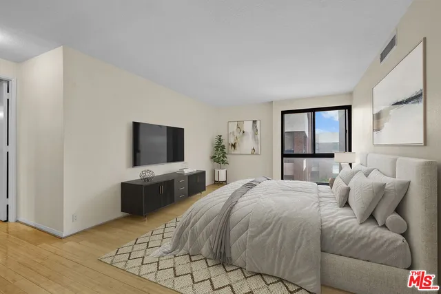 a bedroom with a large bed and a flat screen tv