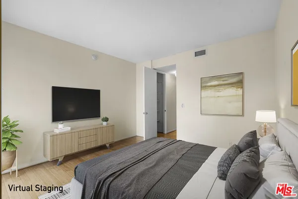 a bedroom with a bed and a flat screen tv