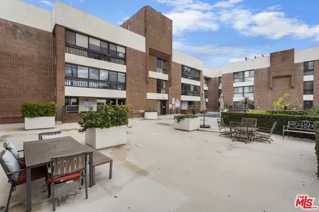 a view of a patio with a table and chairs and potted plants