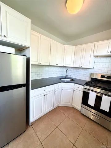 a kitchen with granite countertop white cabinets and white appliances