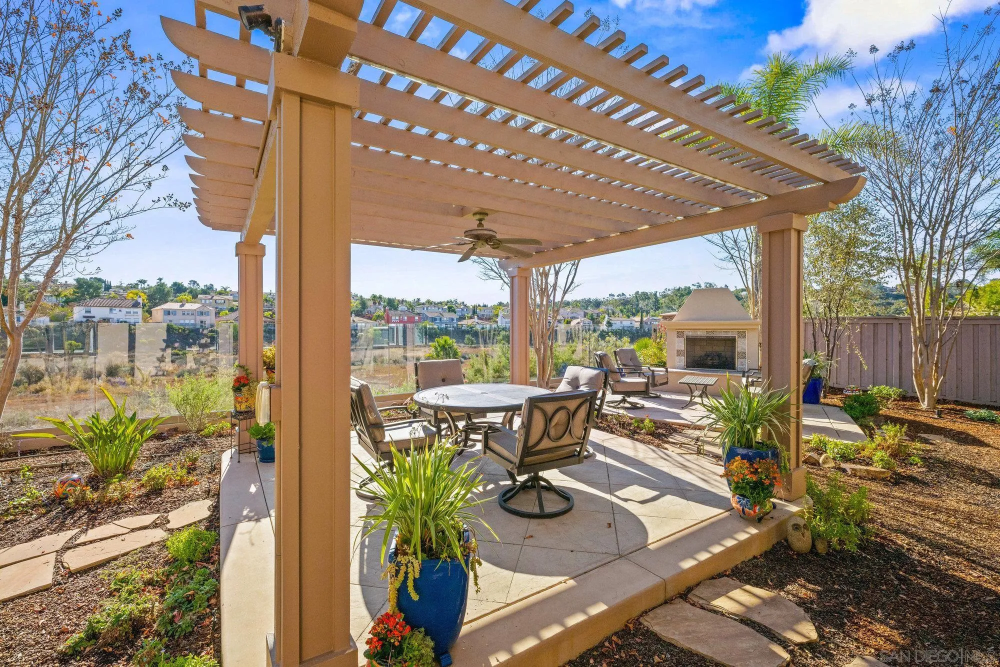 3267 Avenida Aragon Carlsbad, CA 92009 - Photo 5 of 11 a view of a patio with table and chairs potted plants and wooden fence