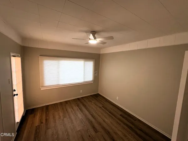 an empty room with wooden floor and window