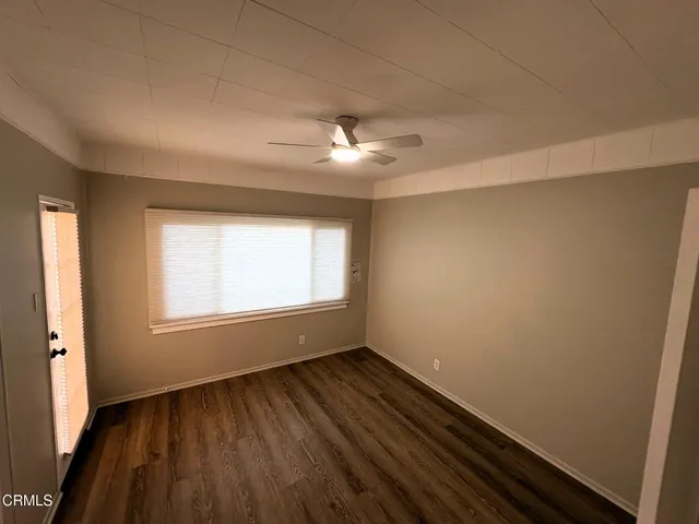 an empty room with wooden floor and window