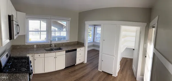 a kitchen with granite countertop a sink and a stove top oven