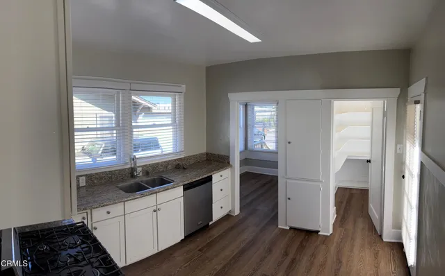 a kitchen with a sink and wooden floor
