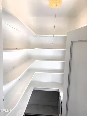 a view of wooden floor and a kitchen in an empty room