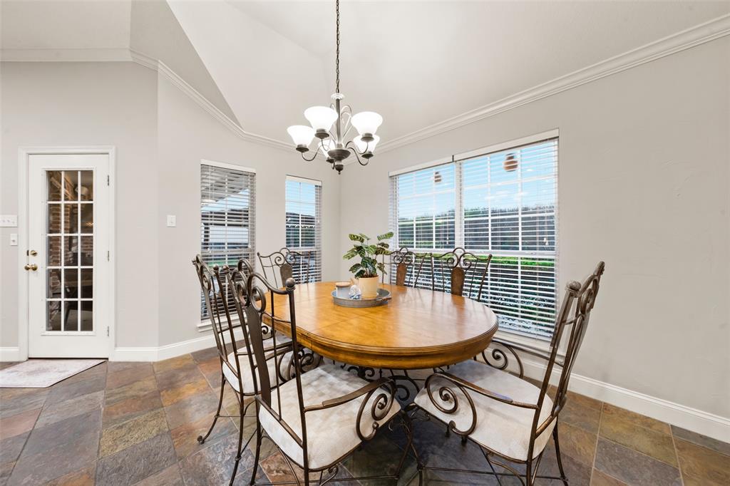 517 Chado Lane Robinson, TX 76706 - Photo 12 of 40 Dining space attached to kithchen with stone tile flooring, hanging lights, healthy amount of natural light, ornamental molding, and vaulted ceiling