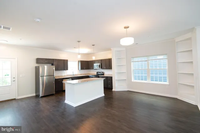 a kitchen with a refrigerator and a stove top oven
