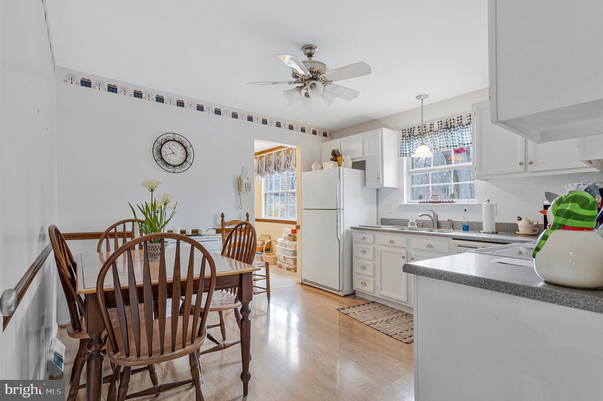 120 Claiborne Road Edgewater, MD 21037 - Photo 4 of 16 a kitchen with stainless steel appliances kitchen island granite countertop a table chairs in it and wooden floors