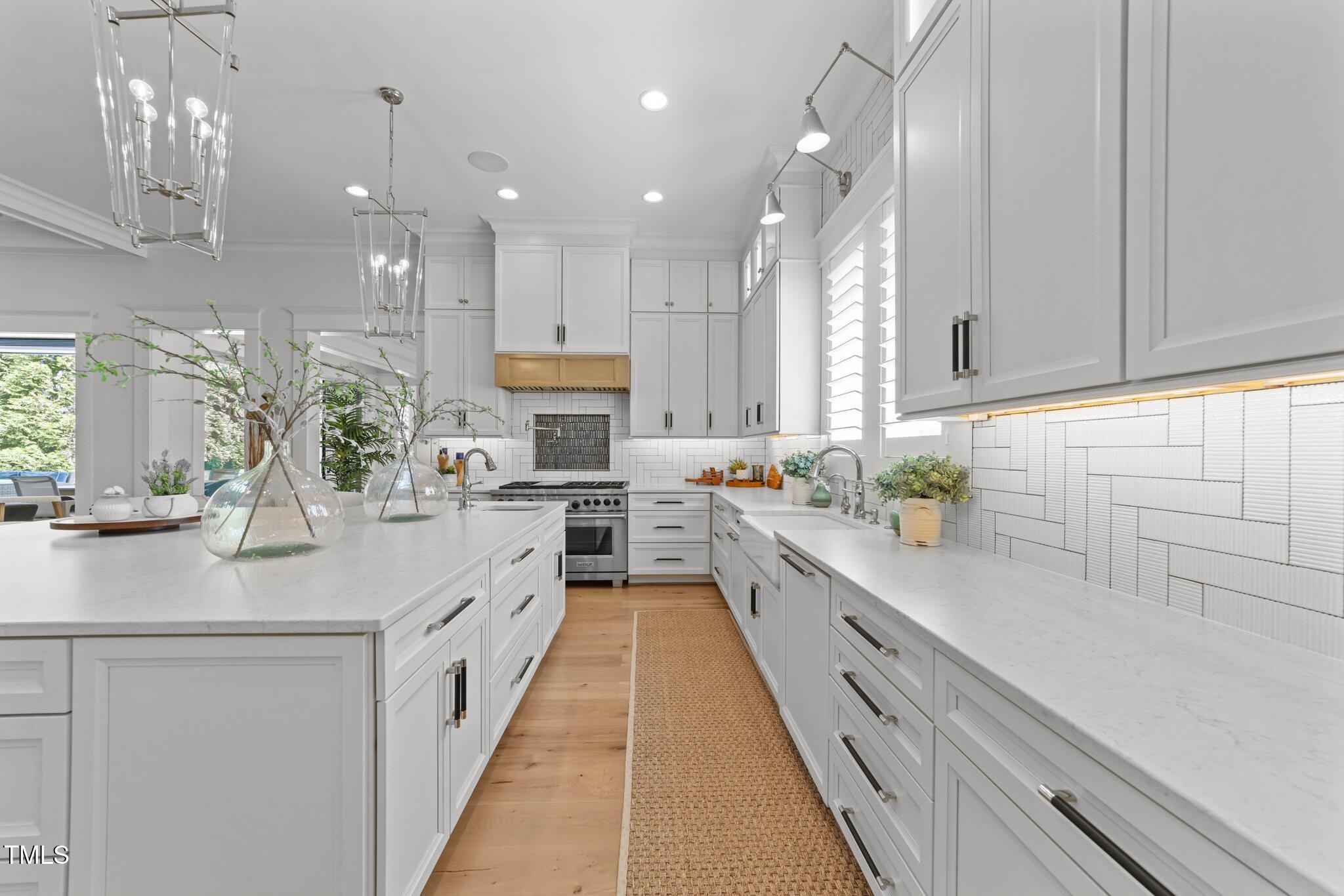 1208 Hunting Ridge Road Raleigh, NC 27615 - Photo 12 of 71 a large white kitchen with lots of counter space wooden floor and stainless steel appliances