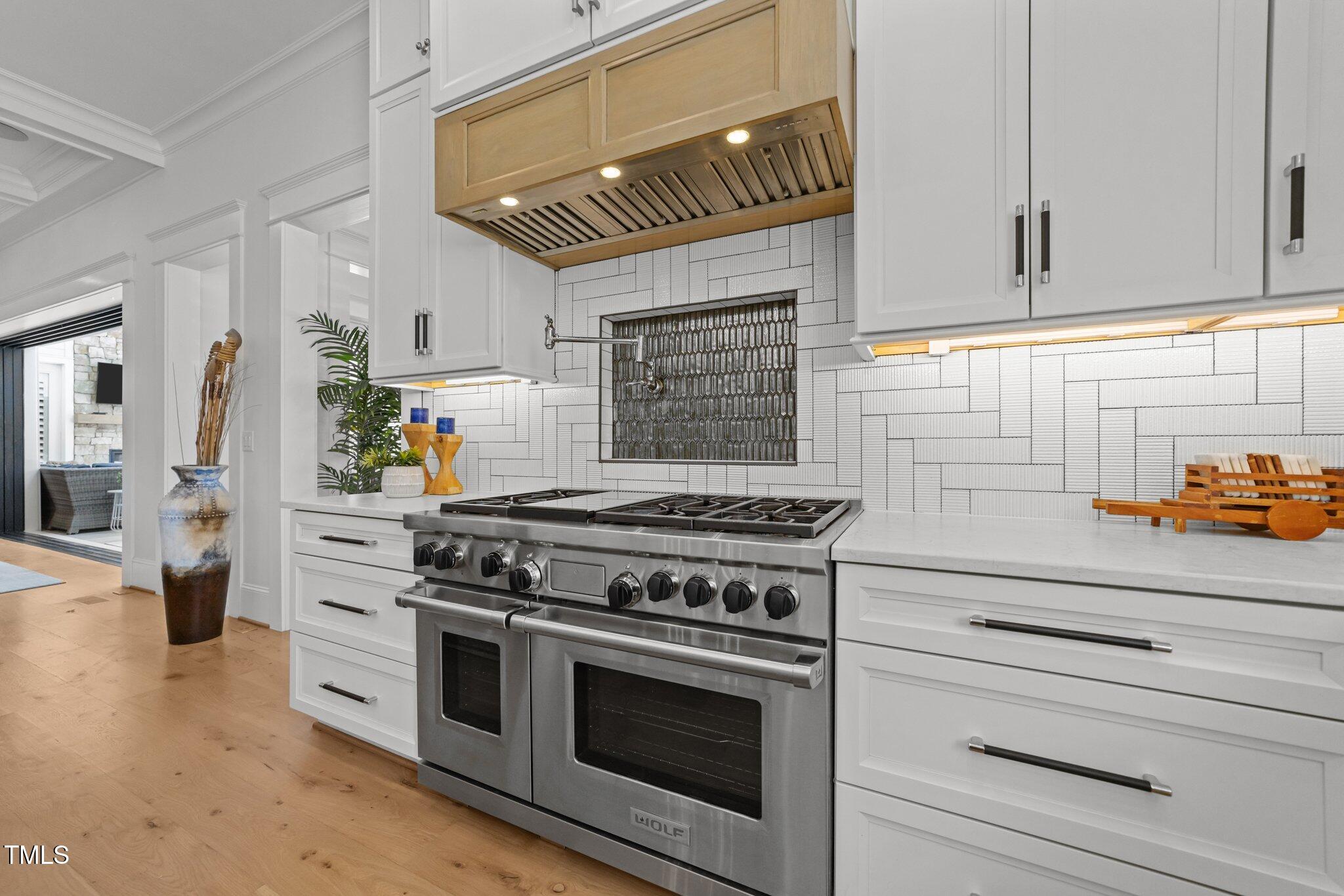 1208 Hunting Ridge Road Raleigh, NC 27615 - Photo 13 of 71 a kitchen with stainless steel appliances white cabinets and a stove top oven