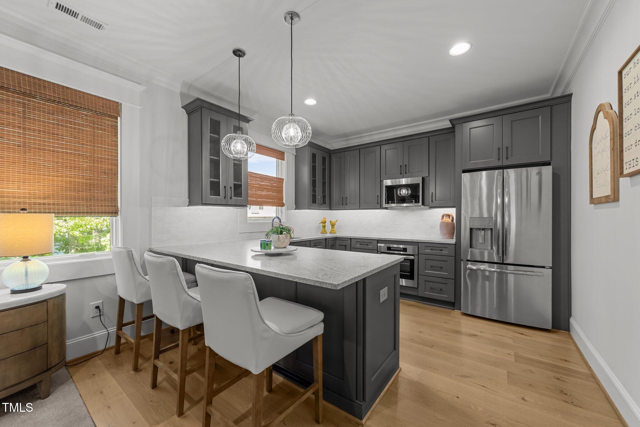 1208 Hunting Ridge Road Raleigh, NC 27615 - Photo 34 of 71 a kitchen with stainless steel appliances granite countertop a sink a stove a refrigerator dining table and chairs