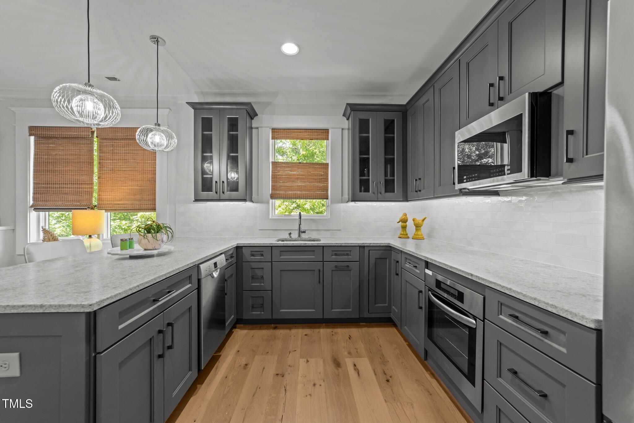 1208 Hunting Ridge Road Raleigh, NC 27615 - Photo 35 of 71 a kitchen with stainless steel appliances granite countertop a sink a stove and a wooden floors