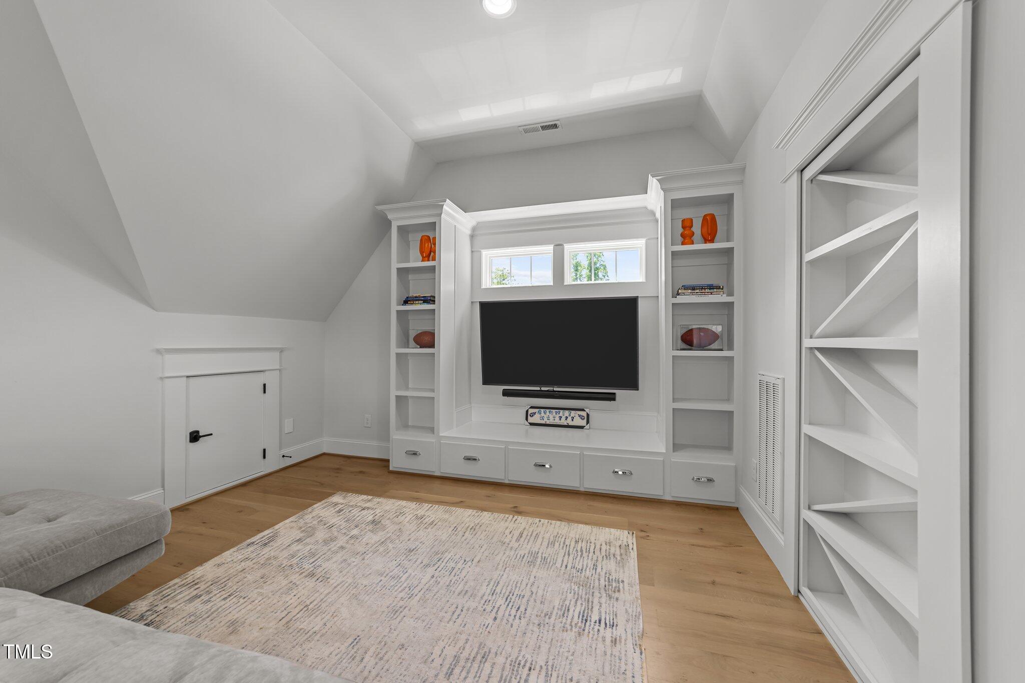 1208 Hunting Ridge Road Raleigh, NC 27615 - Photo 42 of 71 a view of a livingroom with wooden floor and a flat screen tv