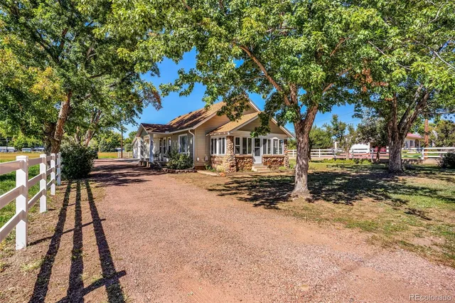 a front view of a house with a tree