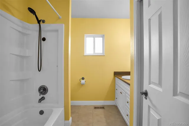 a bathroom with a tub shower and sink
