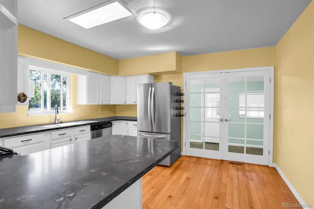 a view of a kitchen with wooden floor and electronic appliances