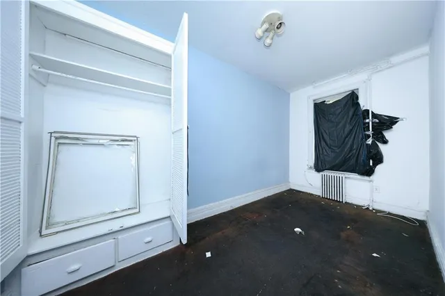 a view of an empty room with a fireplace and a window