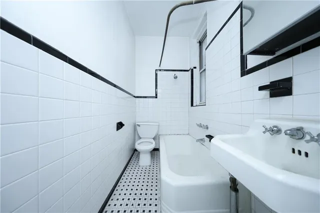 a view of a room with wooden floor a ceiling fan and windows