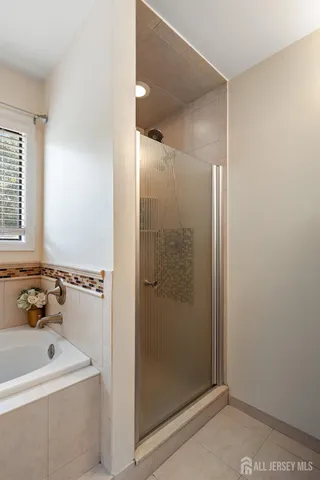 a bathroom with a tub a sink and a shower