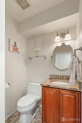 a bathroom with a granite countertop toilet sink and mirror